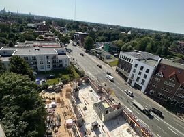 14.08.2025: Auf der Baustelle sind die Arbeiten am Erdgeschoss in unterschiedlichen Bauabschnitten fortgeschritten. Im ersten Bauabschnitt wurde die Bodenplatte bereits vollständig hergestellt, und die Betonarbeiten für die tragenden Wände im Erdgeschoss haben begonnen. Erste Wände und Schächte sind betoniert, die Schalungs- und Bewehrungsarbeiten für weitere Wandabschnitte laufen. Das Arbeitsumfeld ist eingerichtet, Material liegt geordnet bereit, und Gerüste an den Außenkanten sichern die laufenden Arbeiten. Im zweiten Bauabschnitt ist der Rohbau des Erdgeschosses bereits vollständig fertiggestellt. Sämtliche tragenden Wände sind errichtet, und die Baustelle hat nahtlos mit den Rohbauarbeiten im 1. Obergeschoss begonnen. Hier werden aktuell die ersten tragenden Wände des 1. Obergeschosses gestellt, während gleichzeitig vorbereitende Maßnahmen für die das 2.Obergeschoss getroffen werden.